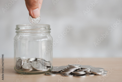 Saving finance business investment concept. Hand of male or female putting coins in jar with money stack step growing growth saving money. Investment And Interest Concept.