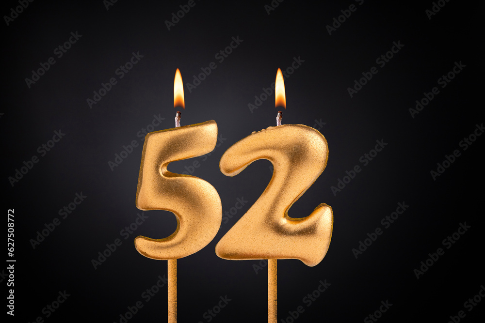 Golden candle 52 with flame - Birthday card on dark luxury background Golden candle 52 with flame - Birthday card on dark luxury background