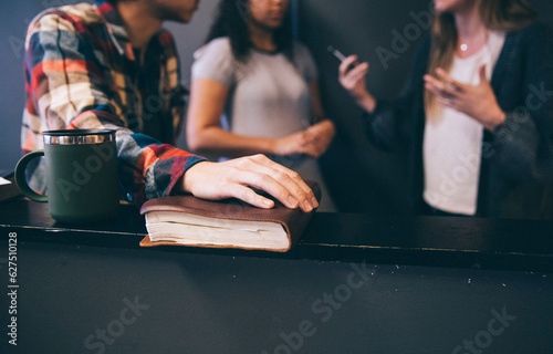 cropped photo of young adults youth talking while holding their bibles leather journal notebook and coffee to-go mug cup and books school college library