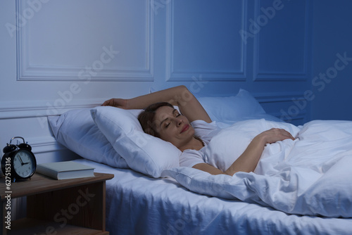 Beautiful woman sleeping in bed at night photo