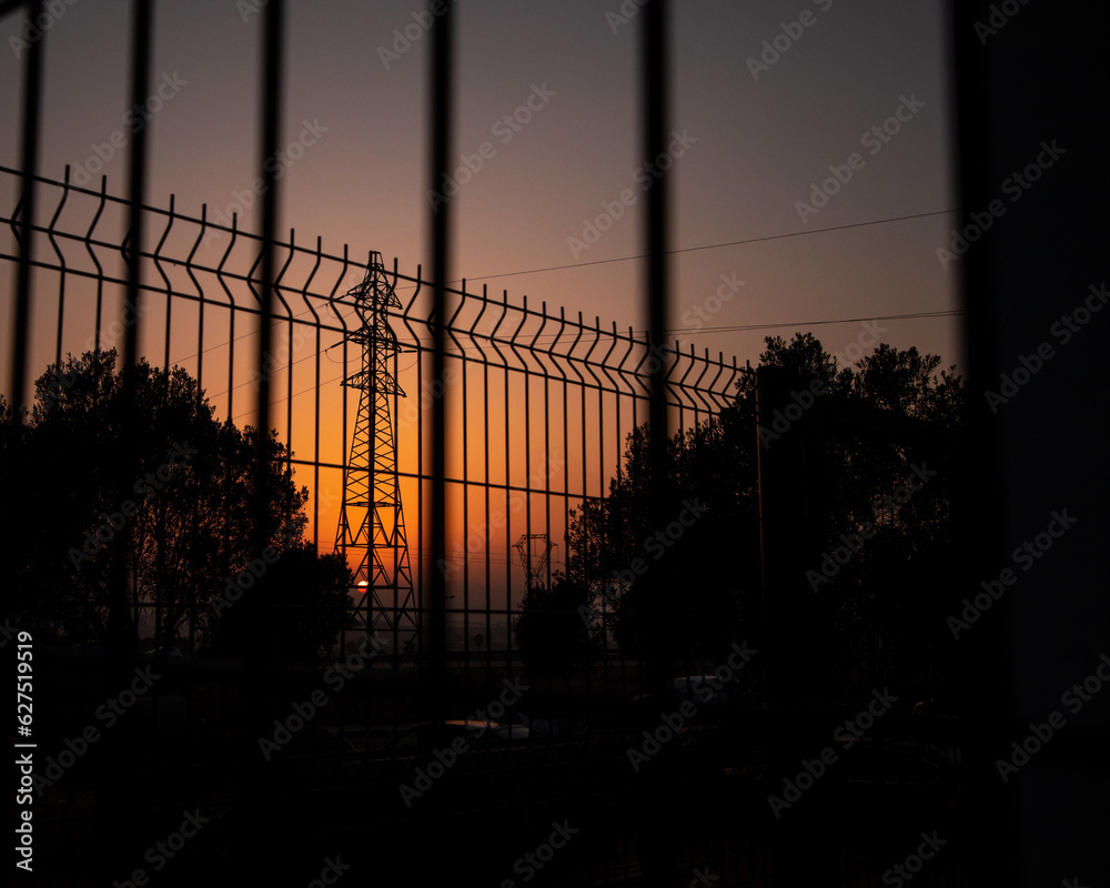 The shadow of an electric pole, during an orange sunset, the shadows of trees in the sunset,View from among the wires