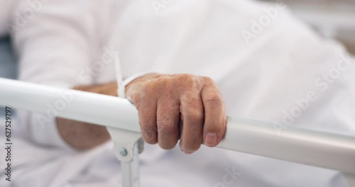 Hand on rail, patient and hospital bed for healthcare, wellness and healing in clinic after cancer surgery. Medical treatment, sick and person in bedroom with health problem in hospice of clinic photo