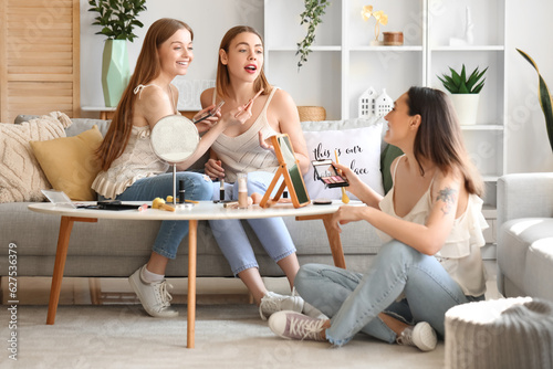 Young women doing makeup at...