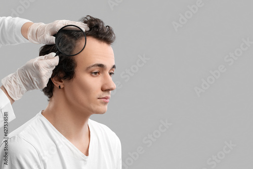 Doctor examining young man ...