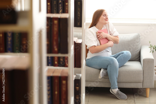 Young woman with book sitti...