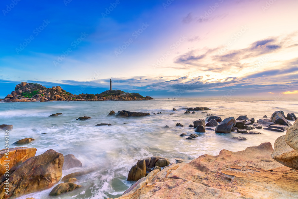 Landscape of the small island with the ancient lighthouse at sunset sky is beautiful and peaceful. This is the only ancient lighthouse is located on the island in Vietnam