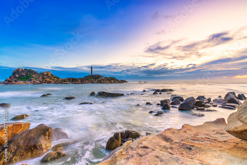Landscape of the small island with the ancient lighthouse at sunset sky is beautiful and peaceful. This is the only ancient lighthouse is located on the island in Vietnam