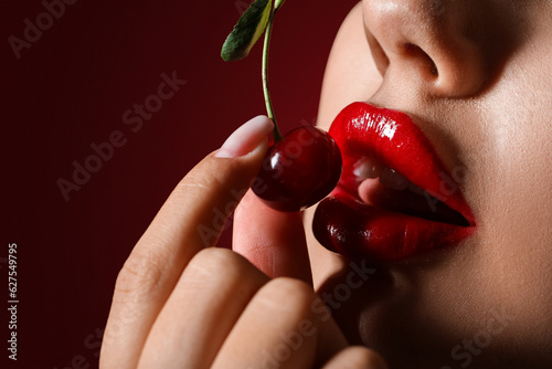 Cuadro en lienzo Beautiful woman with red lips and cherry on dark background, closeup