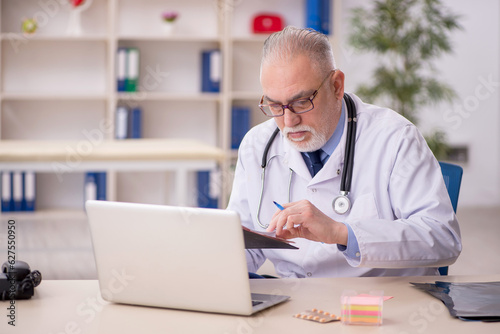 Old male doctor working in the clinic