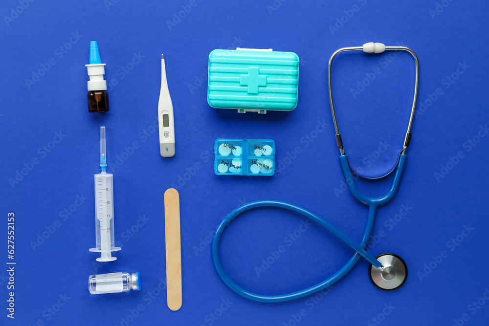 Medical stethoscope, syringe, first aid kit and pill box on blue background Stock Photo Adobe