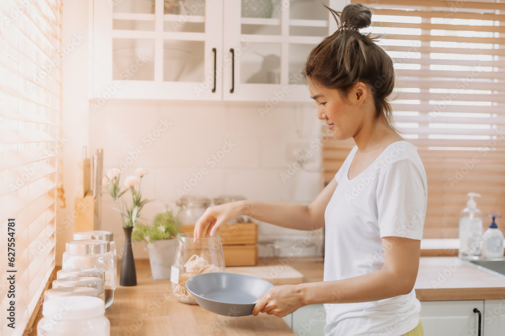 Asian woman preparing breakfast in the kitchen in the morning. Asian woman preparing breakfast in the kitchen in the morning.