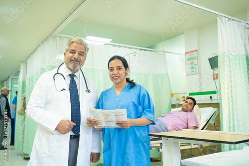 Senior doctor discussing with female assistant after checking patient at hospital