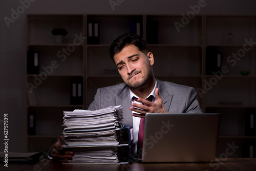 Young male employee working late in the office