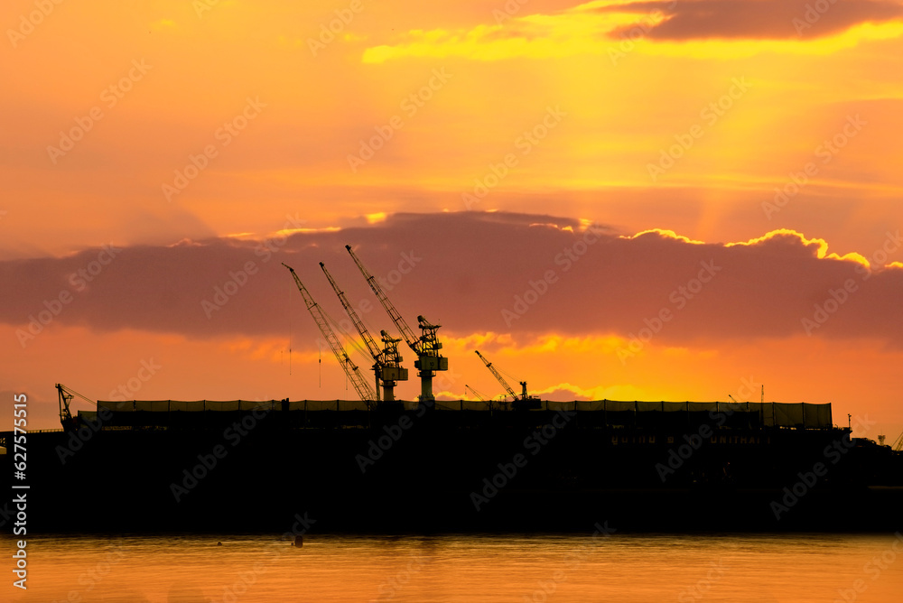 Industry landscape on sunset Engineering shipping crane depot at logistic export terminal control. Silhouette Warehouse freight background container yard loading quayside harbor port with copyspace