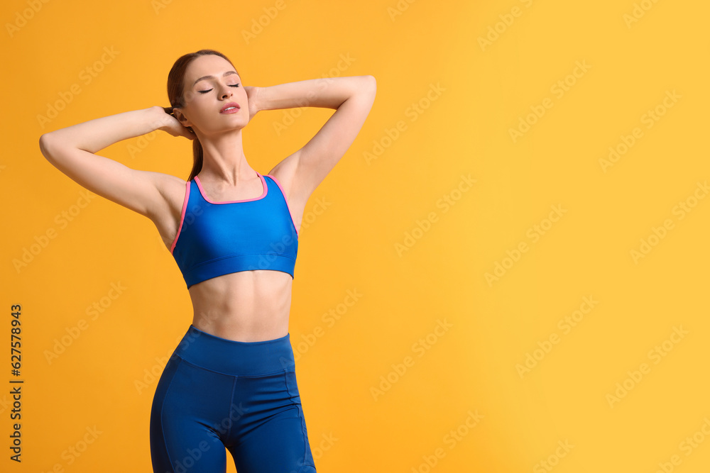 Young woman wearing sportswear on yellow background, space for text