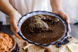 mexican woman cooking mole poblano sauce with chicken traditional food in Mexico Latin America