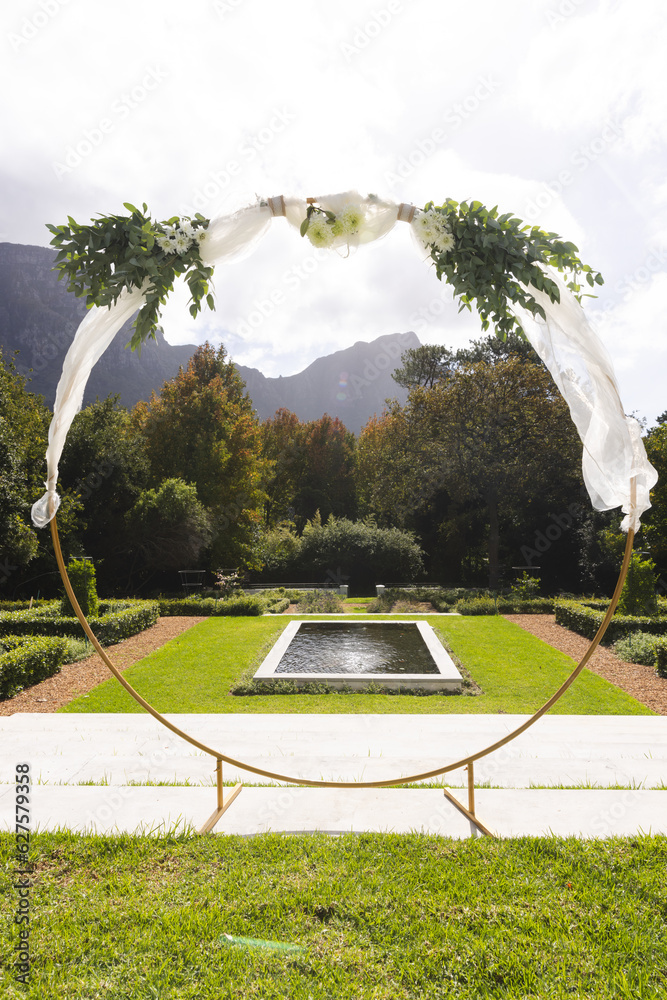Fototapeta premium Decorative wedding arch and pond in sunny garden, copy space