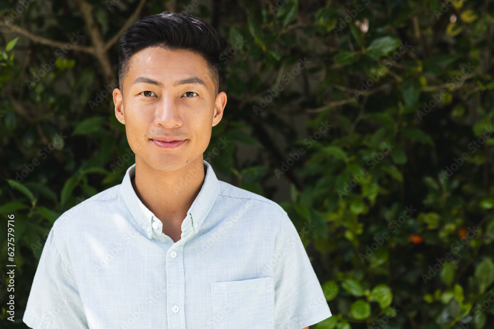 Portrait of happy asian man smiling in sunny garden, copy space Portrait of happy asian man smiling in sunny garden, copy space