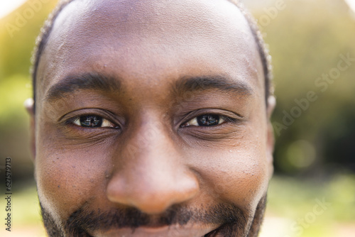 Portrait close up of smiling african american man in sunny garden