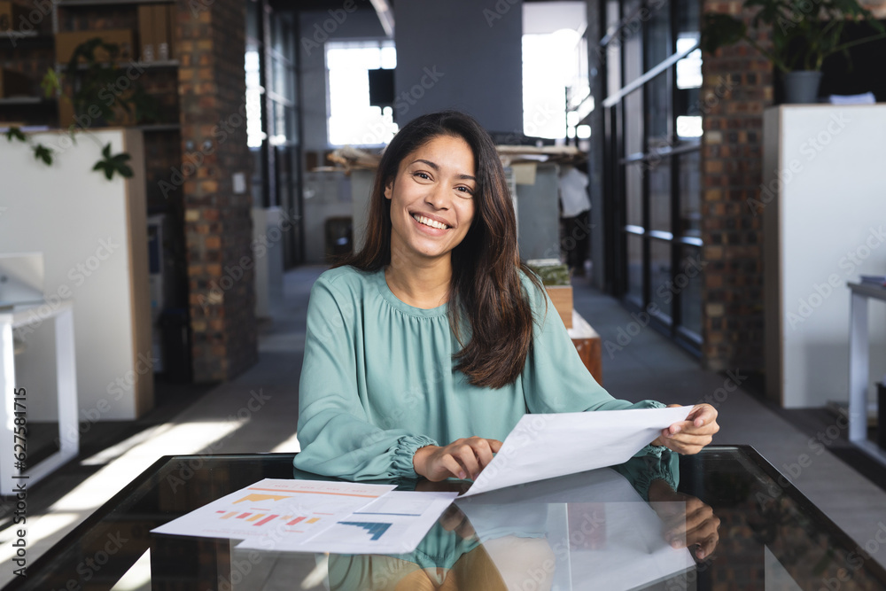 Portrait of happy biracial casual businesswoman having video call with document in office Portrait of happy biracial casual businesswoman having video call with document in office