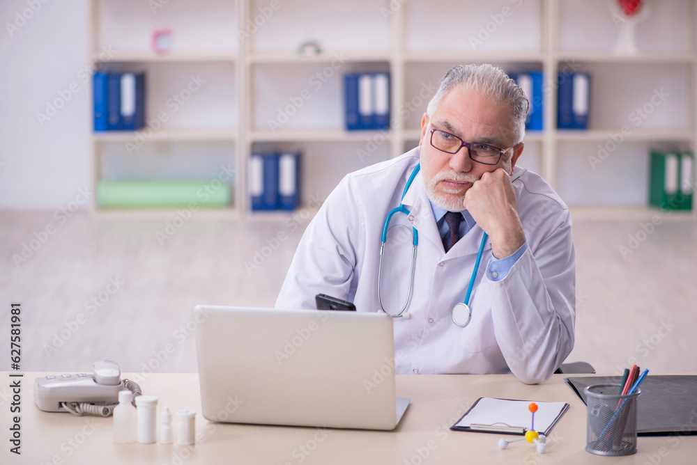 Old male doctor working in the clinic Old male doctor working in the clinic