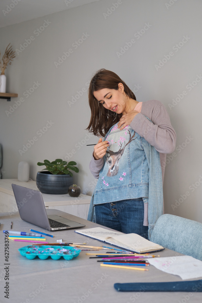 Caucasian woman streaming showing her art design in a denim jacket. Unique clothing designs. Caucasian woman streaming showing her art design in a denim jacket. Unique clothing designs.