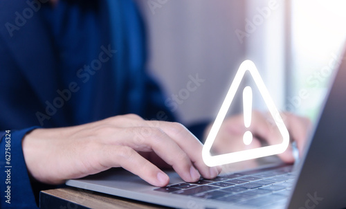 Businessman using laptop showing warning triangle and exclamation sign icon Warning of dangerous problems server error 