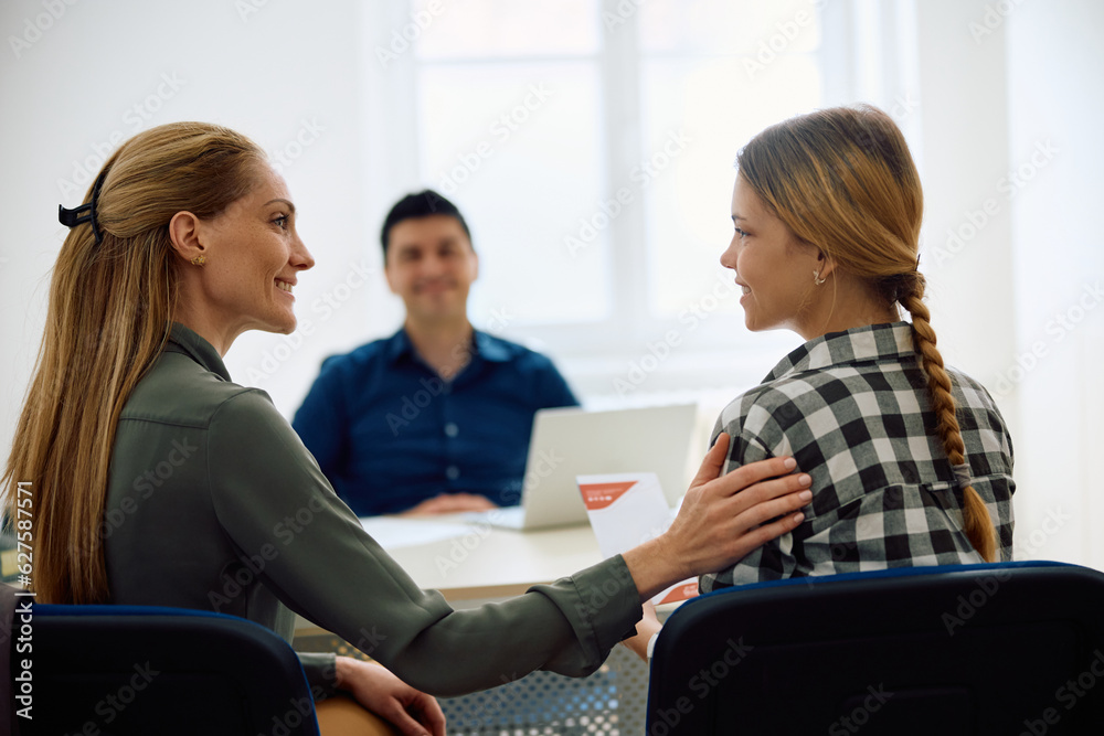 Happy mother and daughter talk while being on meeting with principal during high school enrollment. Happy mother and daughter talk while being on meeting with principal during high school enrollment.