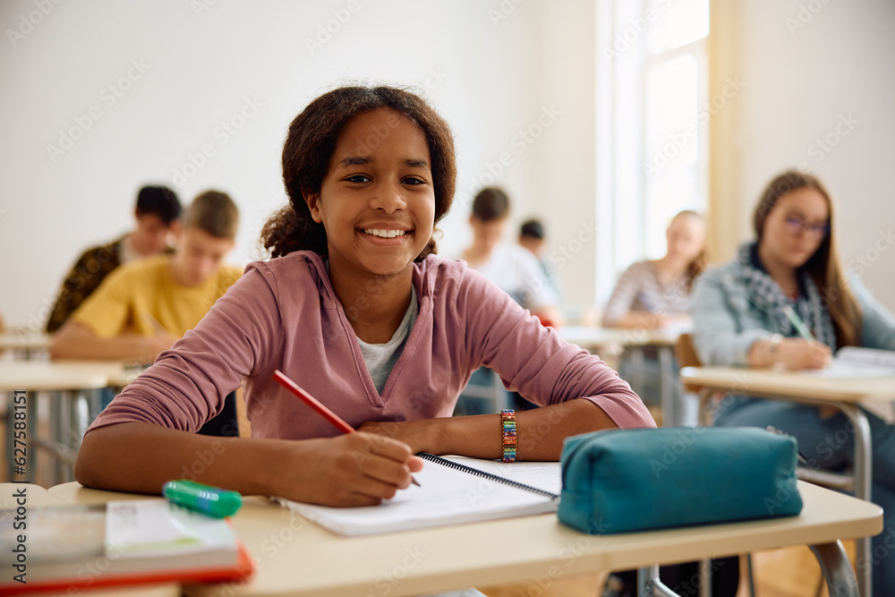 Happy black teenage girl during class at high school looking at camera. Happy black teenage girl during class at high school looking at camera.