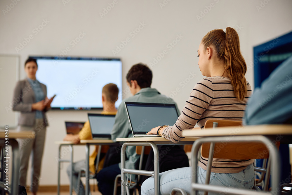 High school student and her classmates attending computer class in classroom. High school student and her classmates attending computer class in classroom.