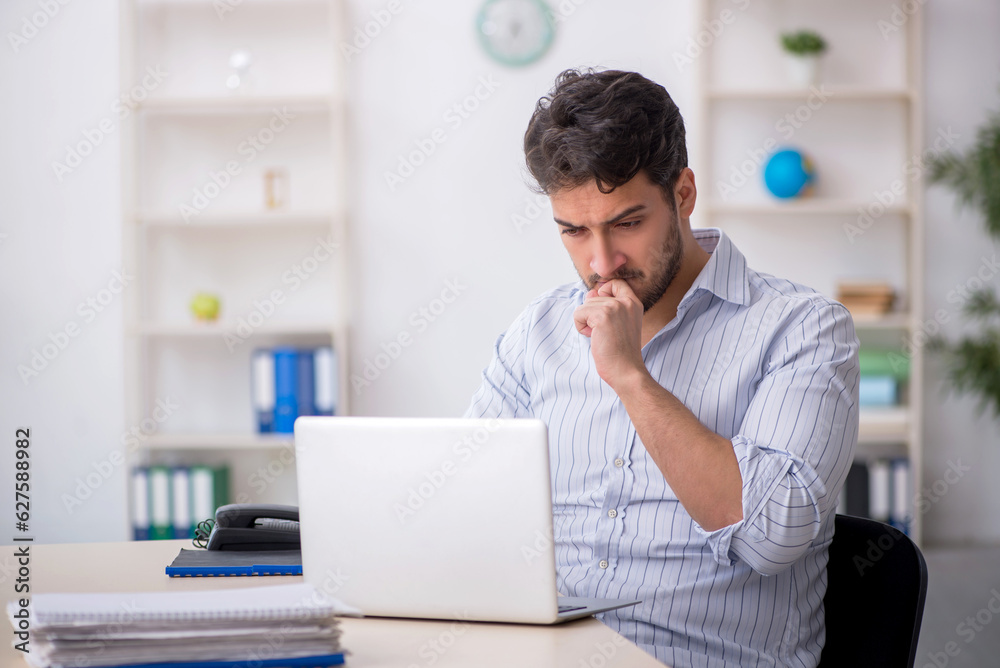 Young male employee working in the office Young male employee working in the office