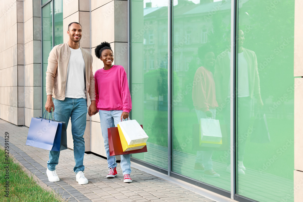 Fototapeta premium Family shopping. Happy couple with colorful bags near mall outdoors