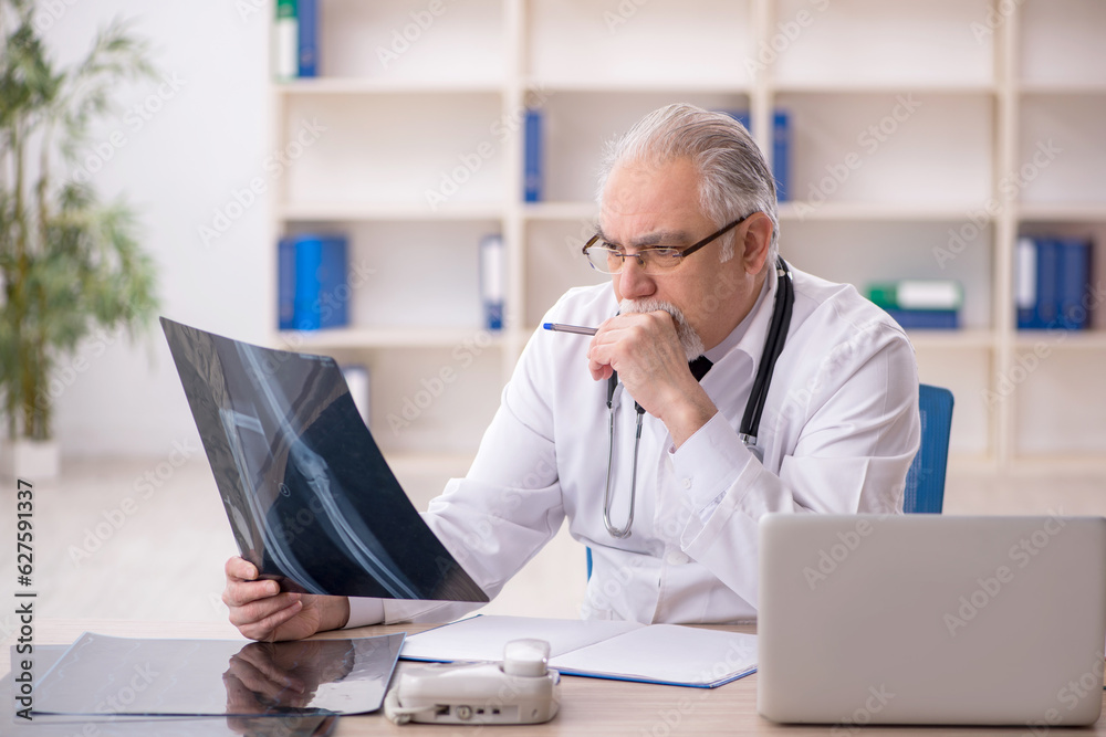 Old male doctor radiologist working in the clinic Old male doctor radiologist working in the clinic