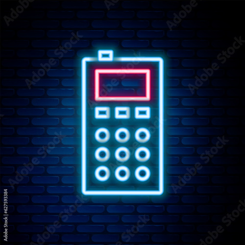 Glowing neon line Remote control icon isolated on brick wall background. Colorful outline concept. Vector
