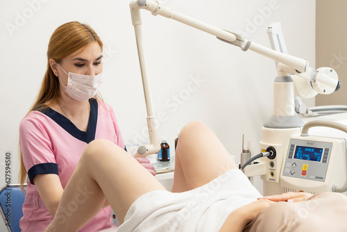  woman doctor, laser gynecology, makes an operation for a middle-aged patient using a Fotona laser device. The concept of laser technology in gynecology and women's health. photo