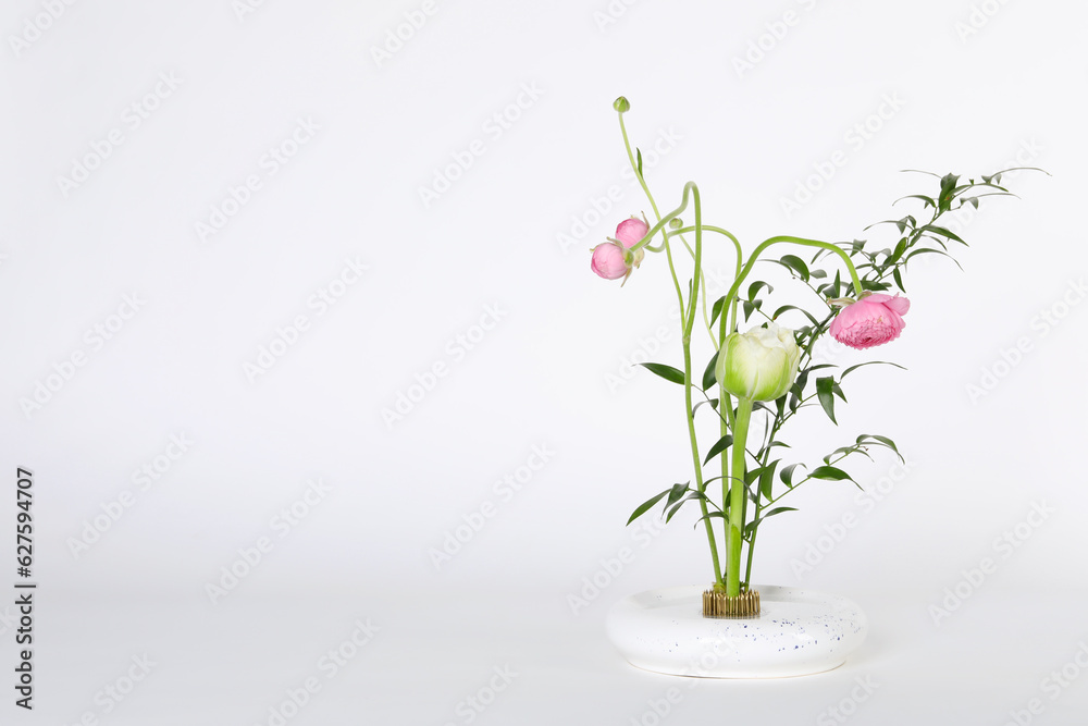 Obraz premium Beautiful ikebana for stylish house decor. Floral composition with fresh flowers and branches on white background, space for text