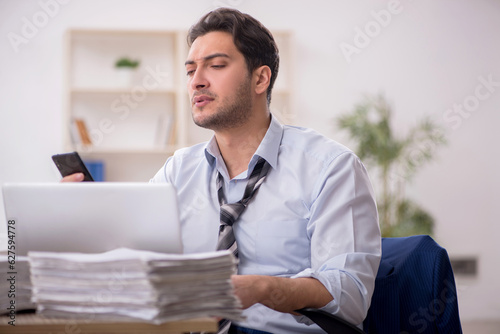 Young male employee and too much work in the office