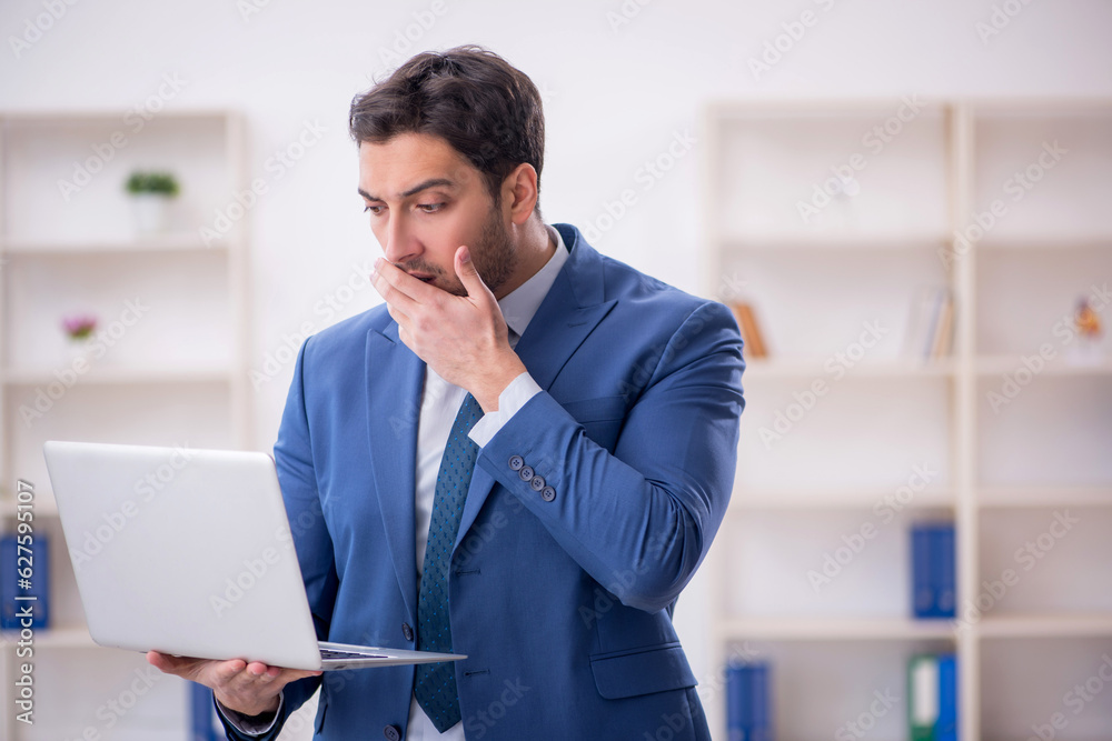 Young male employee working in the office Young male employee working in the office