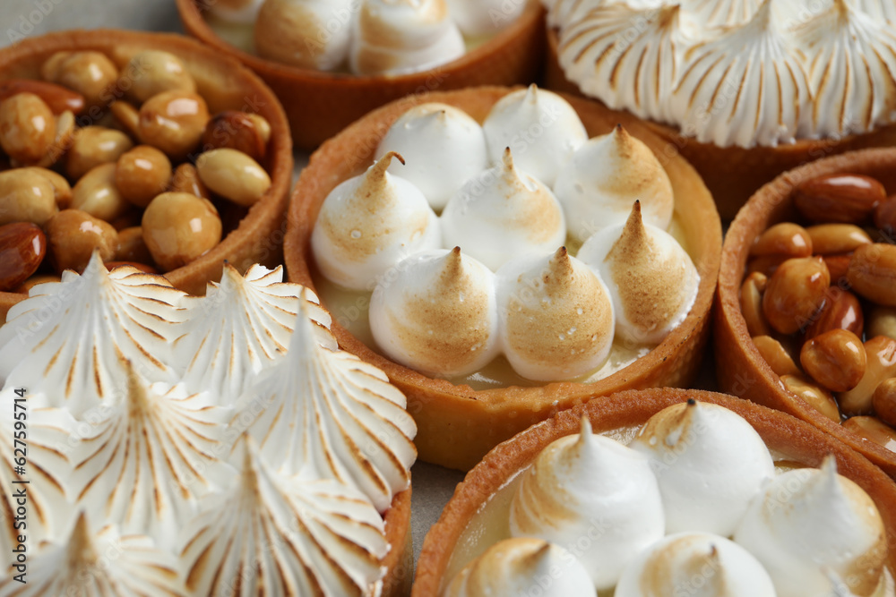 Many different tartlets on grey table, closeup. Delicious dessert