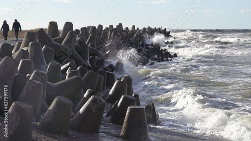 Waves crashing against breakwater consisting of gray concrete tetrapods. Liepaja, Latvia. Liepājas Ziemeļu mols photo