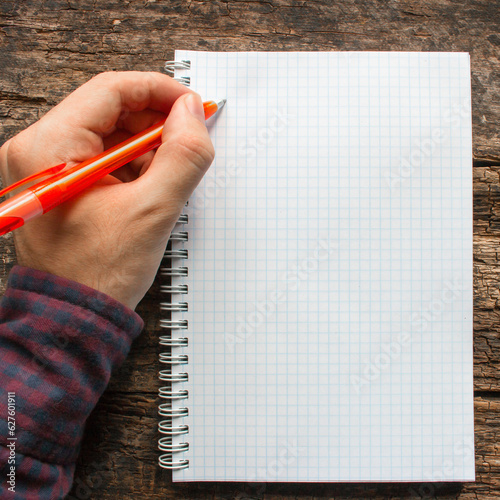 left-handed man writes in a notebook photo