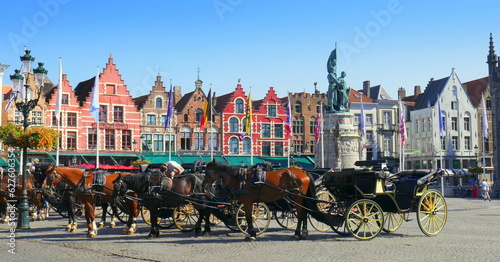 Panorama von malerischem Markt in Brügge in Belgien mit mehreren Pferdekutschen vor alten Häuserfassaden