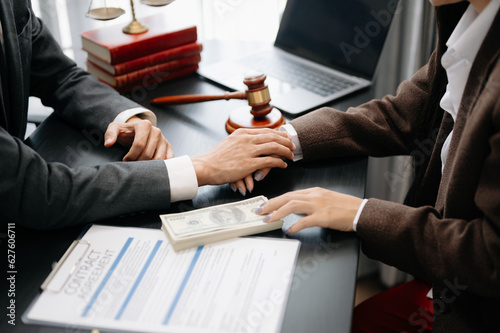 Business people compassionately holding hands and discussing contract papers with laptop and tabletat office .. photo