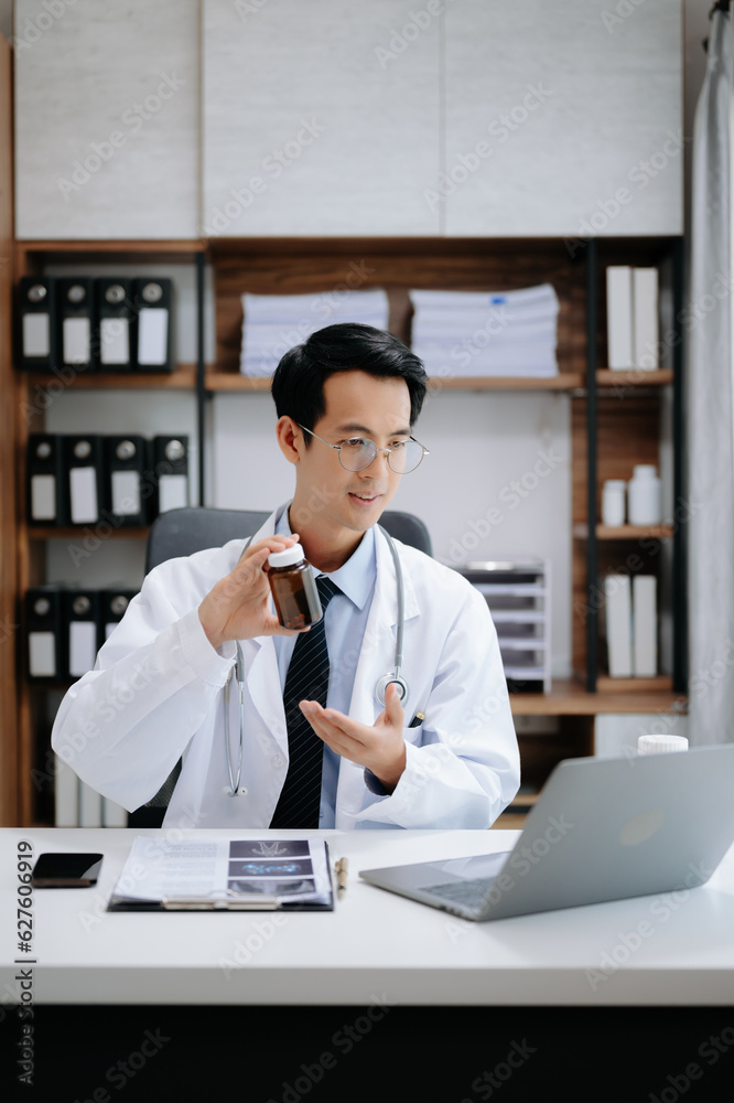 Attractive female doctor talking while explaining medical treatment to patient through a video call with laptop in modern office