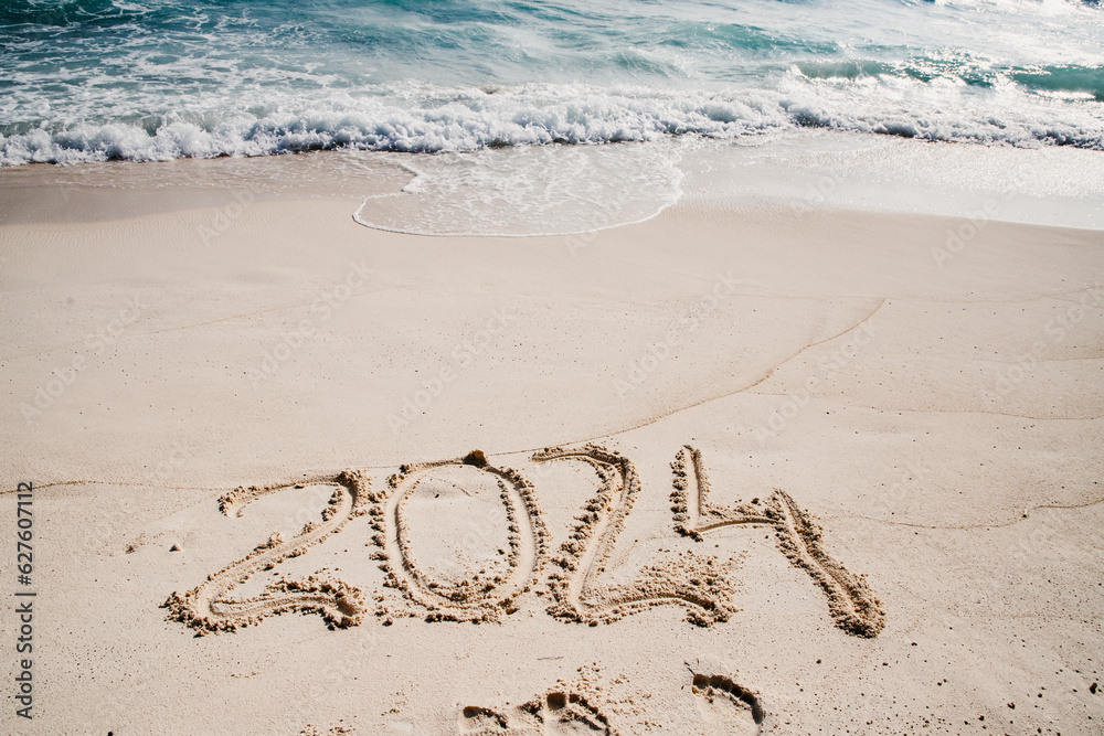 Fototapeta premium 2024 written in white sand on tropical beach, happy New Year