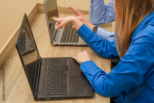Praca biurowa, dwie osoby korzystające z komputerów 
