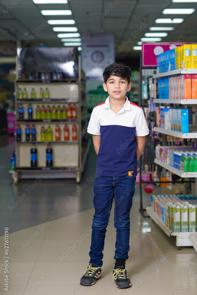 Indian little boy standing at grocery shop.