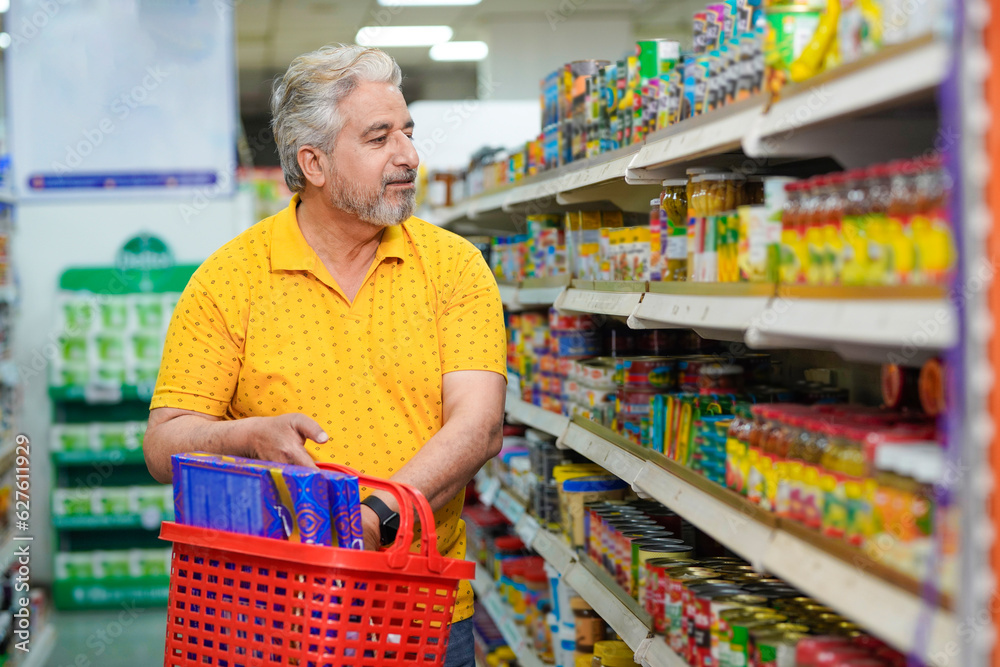 Senior man looking product detail and purchasing at grocery shop.
