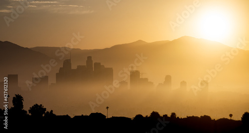 Early morning sunrise over Downtown Los Angeles, sunshine silhouette of the cityscape through the fog