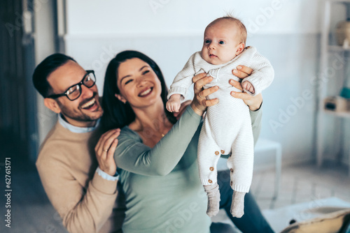Family  adoption  baby  parenthood and people concept. Happy mother father with newborn baby at home